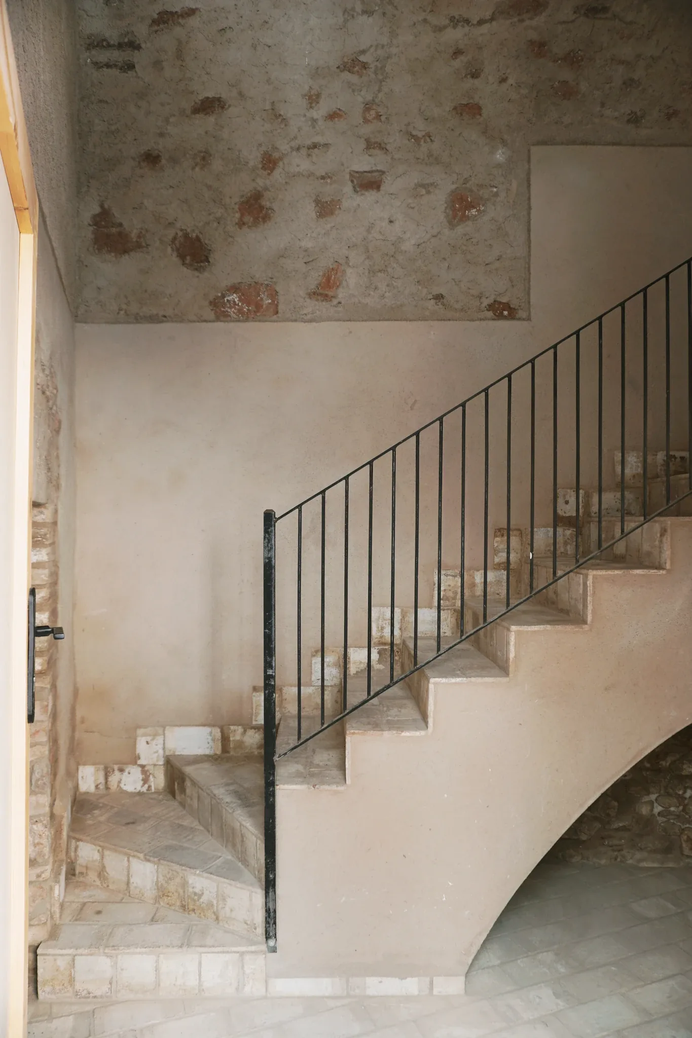 Escalera de hierro junto a un muro de mampostería original vista, reforma en Sant Llorenç Savall