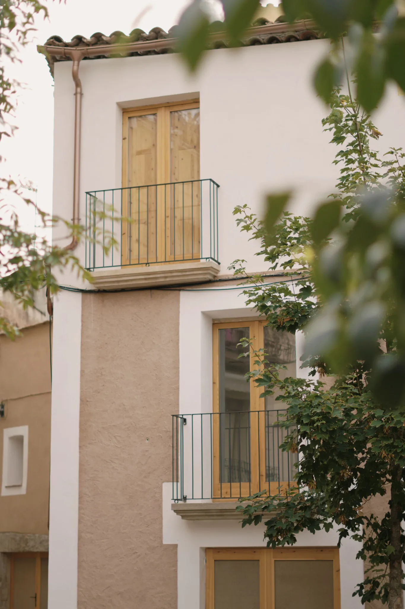 Fachada completa con dos balcones y tejado de teja cerámica, reforma de casa de esquina en Sant Llorenç Savall