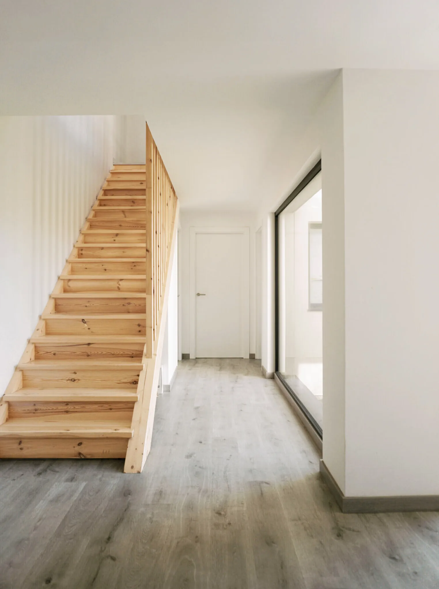 Escalera de madera y pasillo de acceso, vivienda unifamiliar de obra nueva en Lliçà d'Amunt