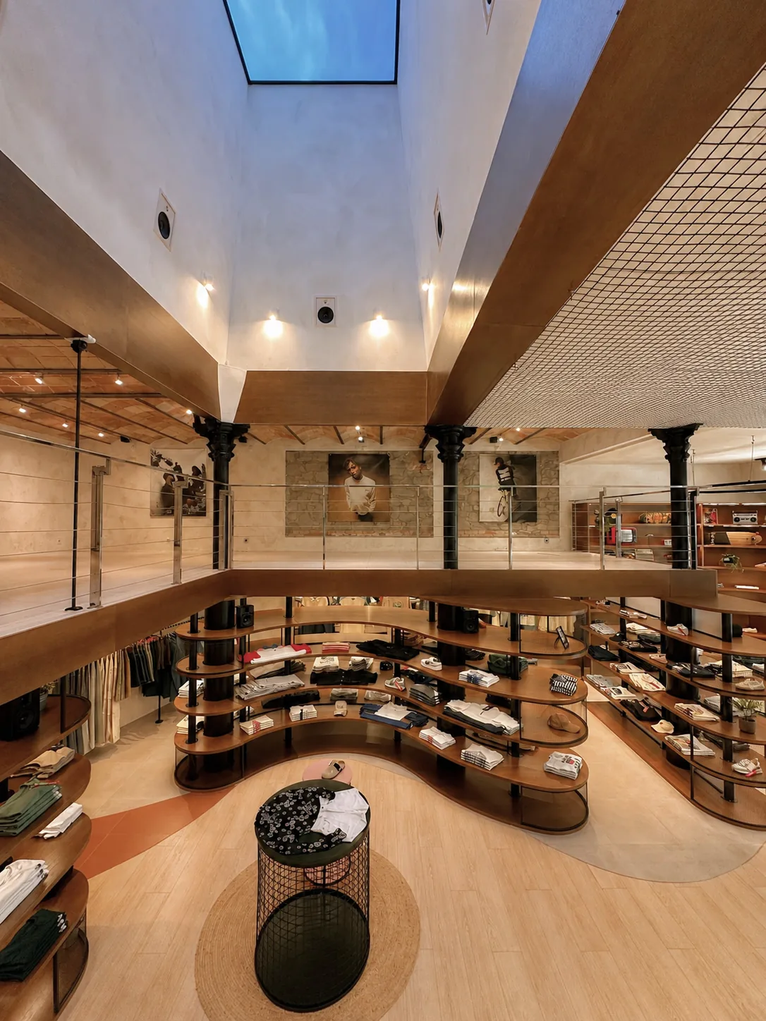 Entreplanta con estantería curva de madera, diseño de espacio comercial Kaotiko, Manresa