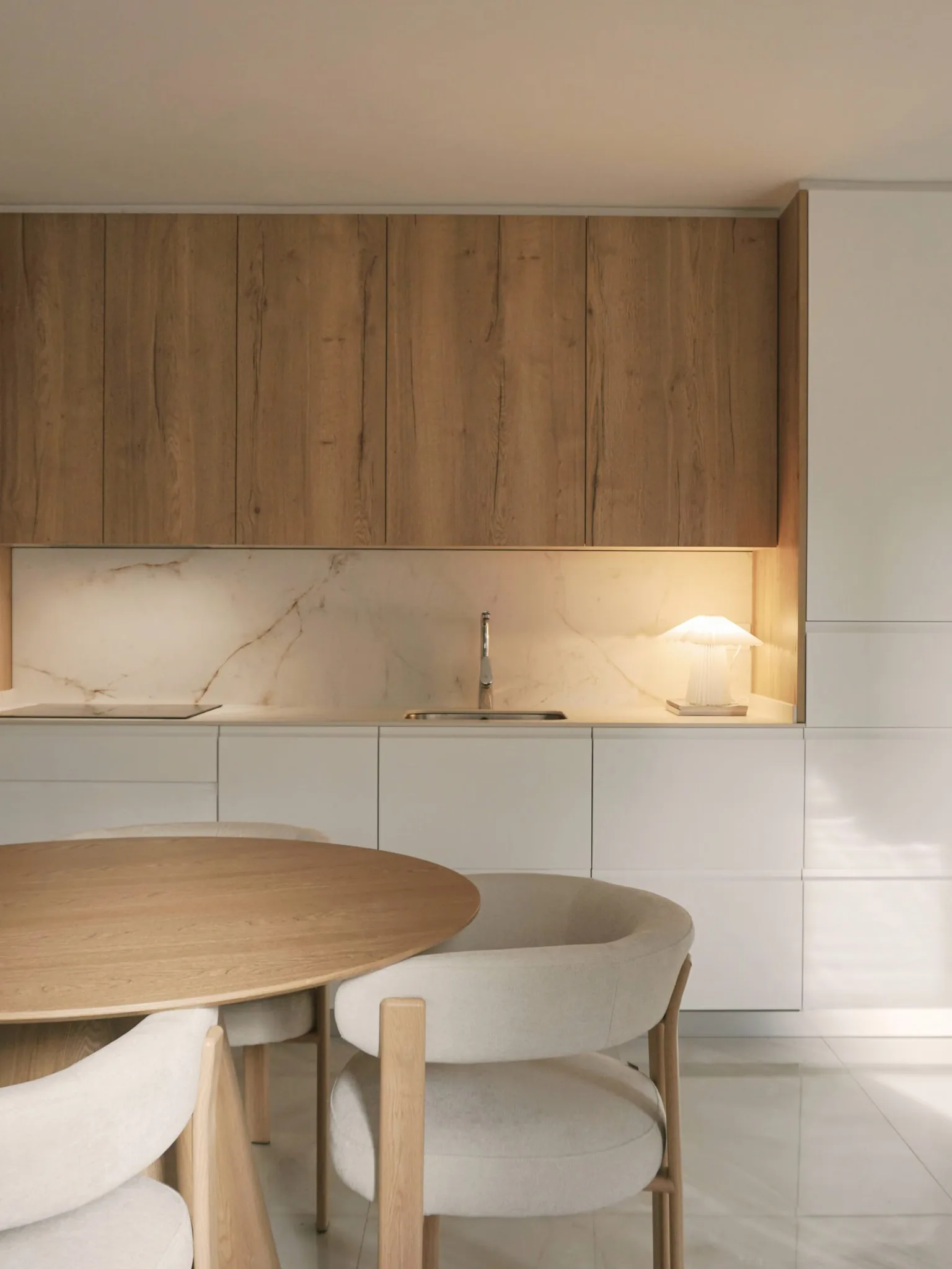 Cocina con encimera de mármol y mesa de comedor circular, reforma residencial en Madrid