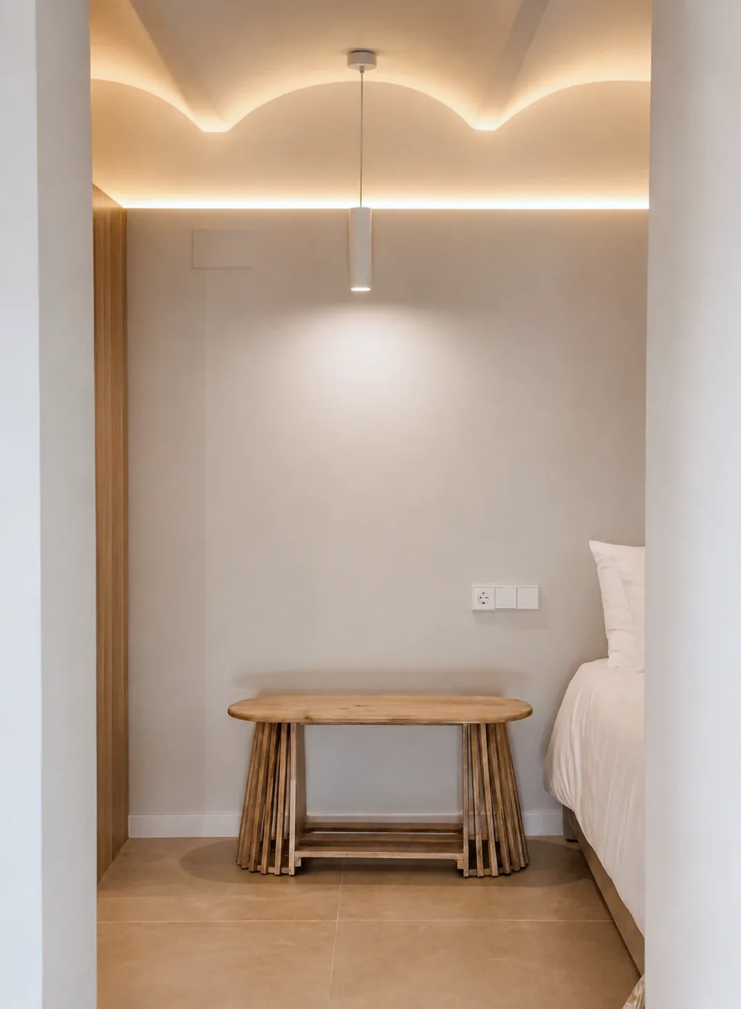 Bóveda catalana recuperada con línea de luz indirecta sobre un banco de madera, reforma integral en Santa Coloma de Gramenet